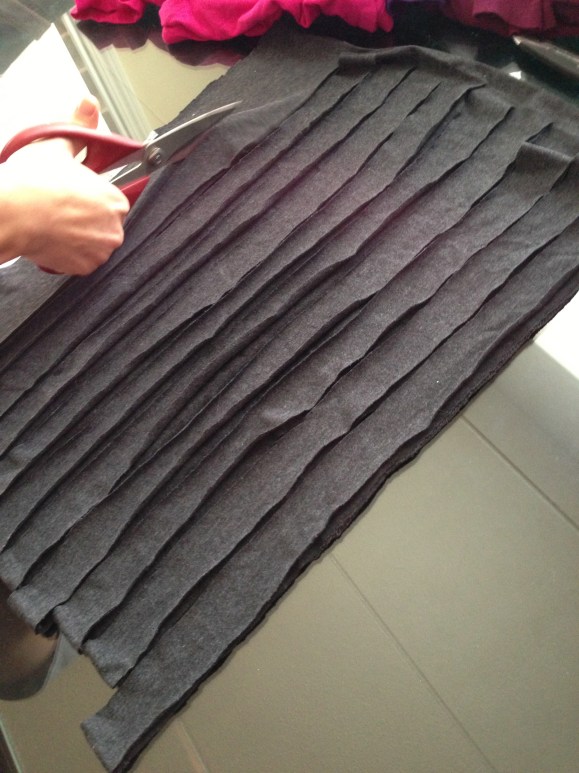 Leaving a half inch at the top of one side, cut from bottom to top in one inch strips. 